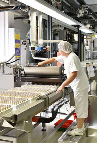 An employee at a manufacturing facility operates a machine