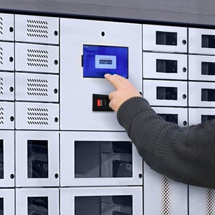 An employee retrieves a tablet from the hotel's smart locker