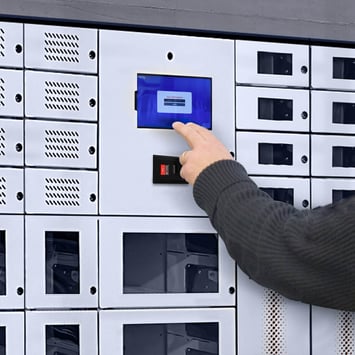 An employee using a smart access panel of a smart locker to retrieve a critical asset