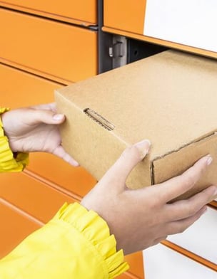 A smart locker ensures the protection of parcels. Using a smart locker, an employee retrieves a package