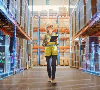 An employee monitors warehouse equipment with a tablet