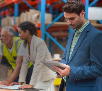 An inventory manager using a tablet at a warehouse to track inventory information