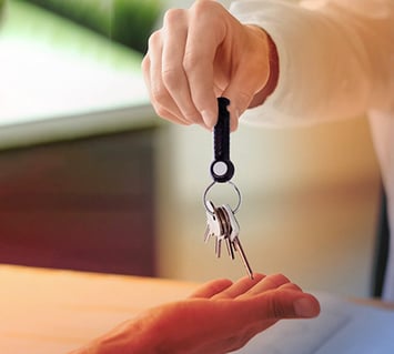 A key set with an indestructible key fob is handed over to an employee