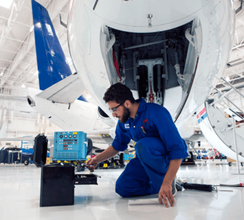 A maintenance engineer repairs the landing gear of an aircraft