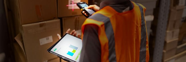 A warehouse employee using a fully charged and working handheld scanner and tablet retrieved from a smart locker