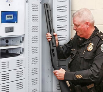 Long guns are retrieved from the smart locker by a police officer