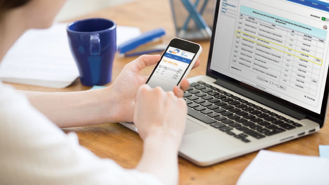 Using her mobile and laptop to operate a key management system