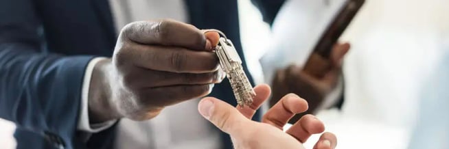 An employee of a hotel hands over hotel keys to another employee