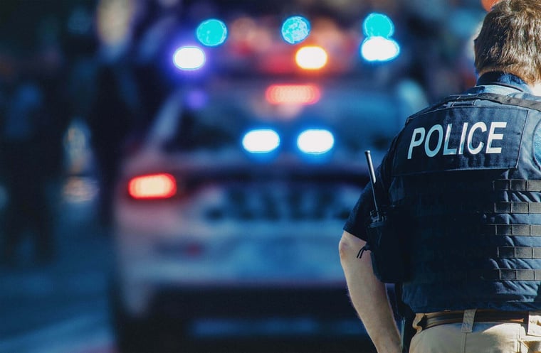 A police officer back showing a POLICE label on his vest
