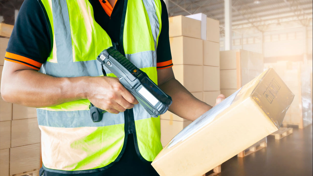 Warehouse employee using a scanner to control inventory