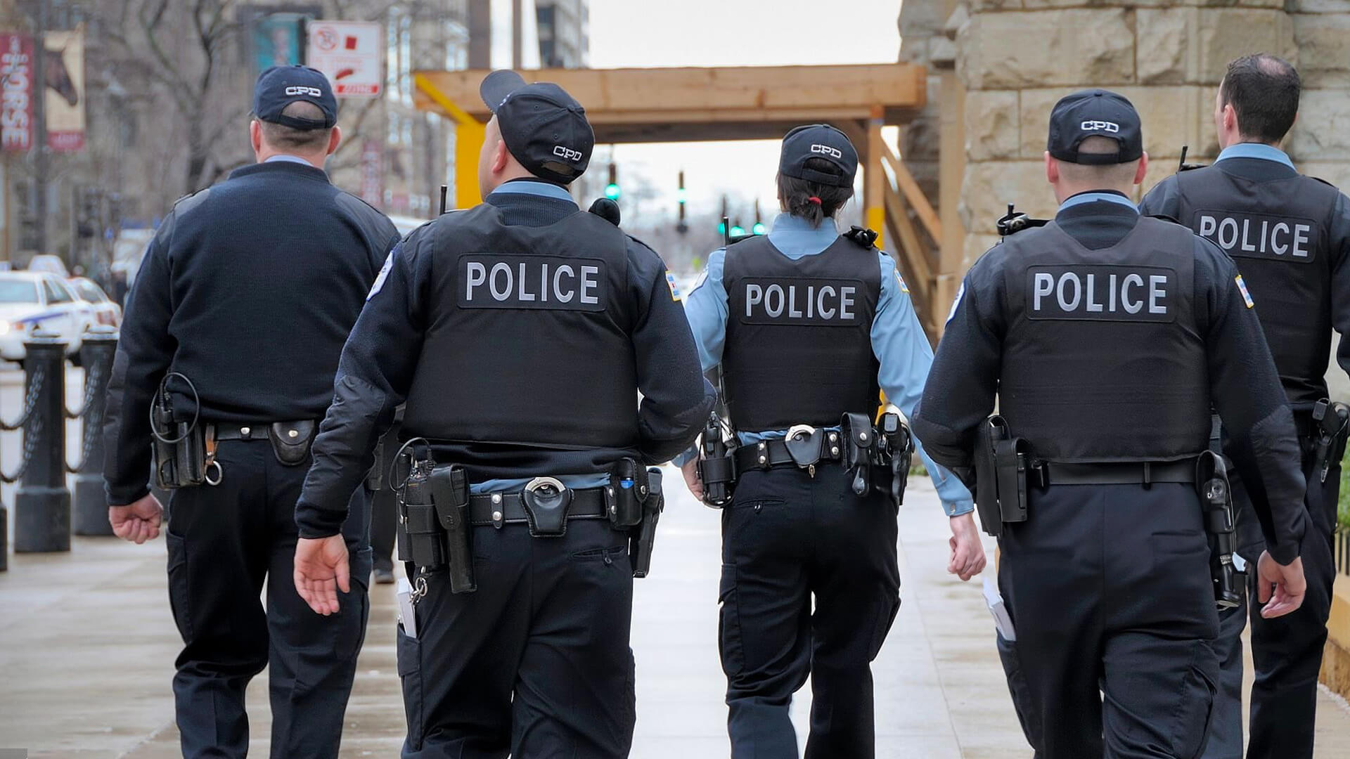 4 police officers walking on the street with their backs to the camera