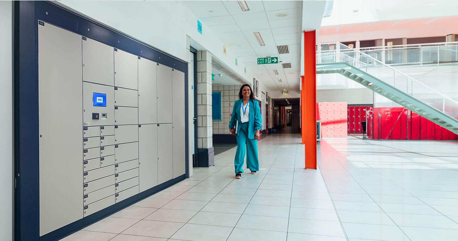 A healthcare institution employee walks next to an AssetTracer smart locker system made by Real Time Networks
