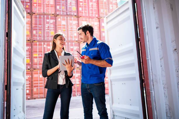 Woman with tablet talking to man in storage container. Concept representing asset tracing using indoor mapping software