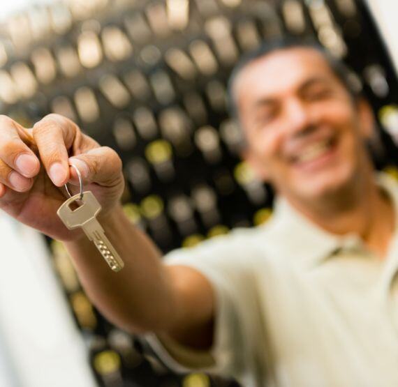 A man handing over a set of keys from a key management system